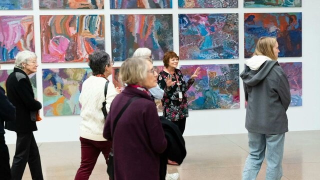 Tour group in front of Emily Kam Kngwarray, Anmatyerr people, The Alhalker suite, 1993 our group in front of Emily Kam Kngwarray's colourful paintings
