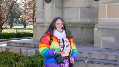 Tour guide Millie wearing a rainbow puffer jacket and headset