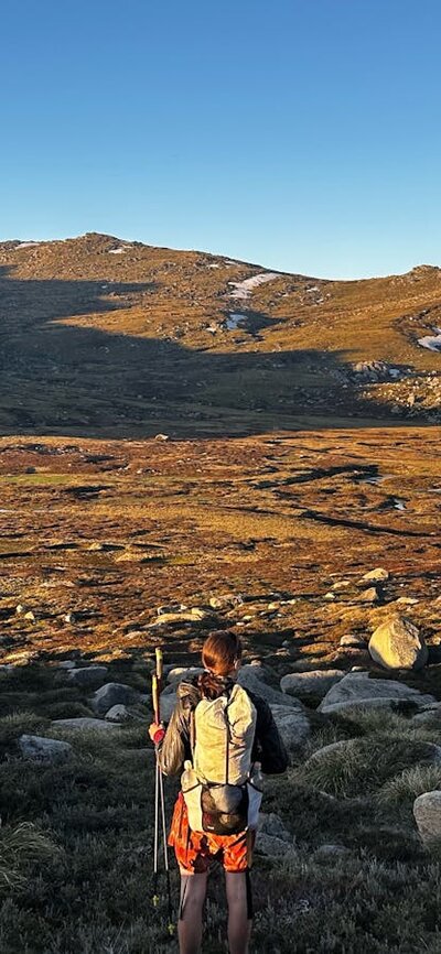 A hiker looking out into a valley in the mountains.