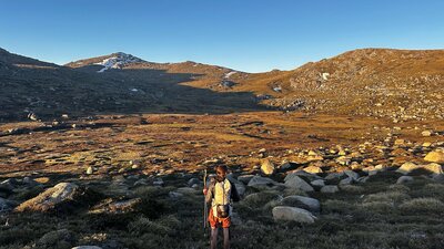 A hiker looking out into a valley in the mountains.