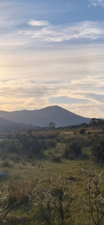 A mountain with the sun setting behind it.