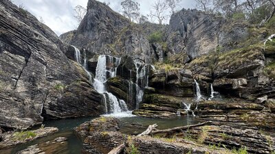 A waterfall leading into a pool of water at the bottom.