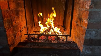 A campfire inside a shelter burning brightly.