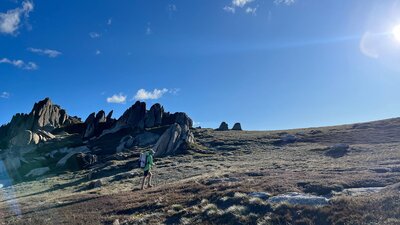 A hiker walking up a slope off track.