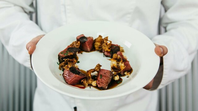 Truffle Lunch Chef holding a beautiful dish made with truffles