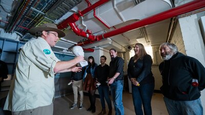 Man in khaki clothing talking to a group of people