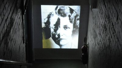 Black and white image of girl projected on a wall