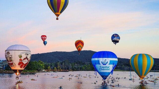 © @zipping12 Images of hot air balloons flying over Lake Burley Griffin with boaters on the water below. | © @zipping12