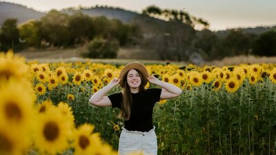 © @tim.j.richardson Woman with a hand standing in the middle of a sunflower maze | © @tim.j.richardson