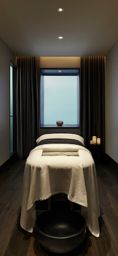 A massage bed and basin at a stylish and modern day spa.