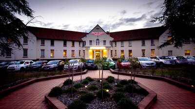 Mercure Canberra Hotel Sunset at the entrance to Mercure Canberra Hotel with cars parked out front.