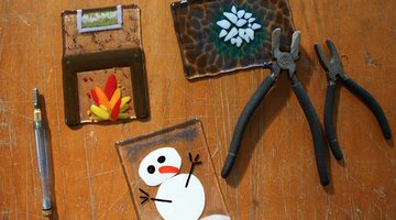 Canberra Glassworks school holiday program Tiles made from glass on a table with art making equipment and tools