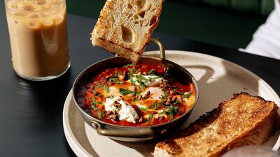 Shakshouka with tomato sugo, tahini labneh, crushed pistachios, parsley and Three Mills focaccia.