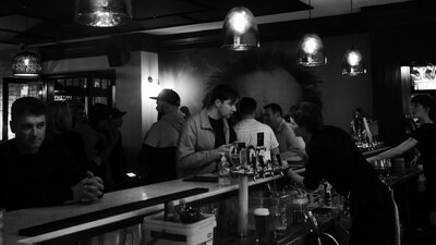 A group of people ordering drinks at a lively bar in the city.