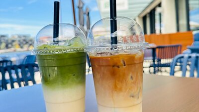 Two different iced drinks on an outside table.