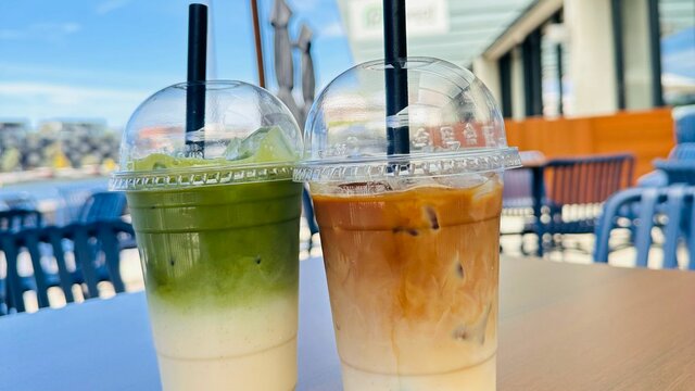 Two different iced drinks on an outside table.