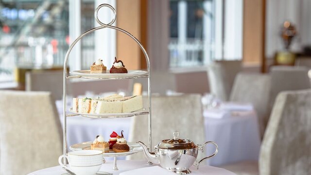 A three-tier traditional high tea stand and teapot