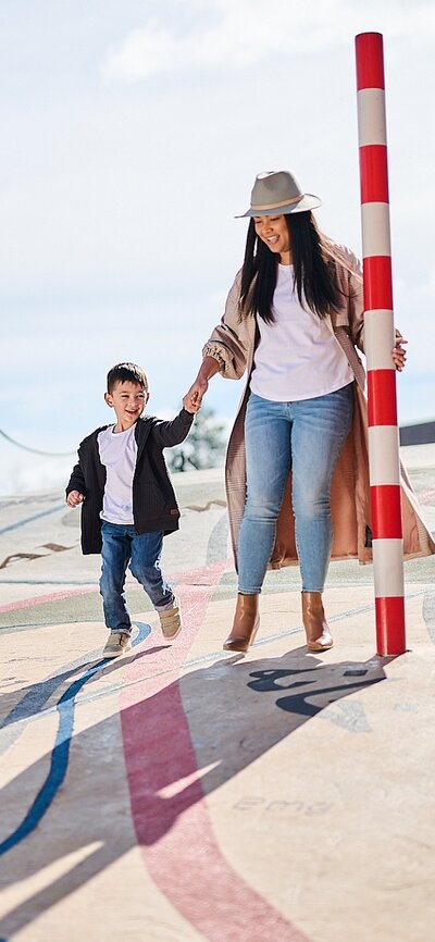 Mum and son holding hand in outside area of National Museum of Australia