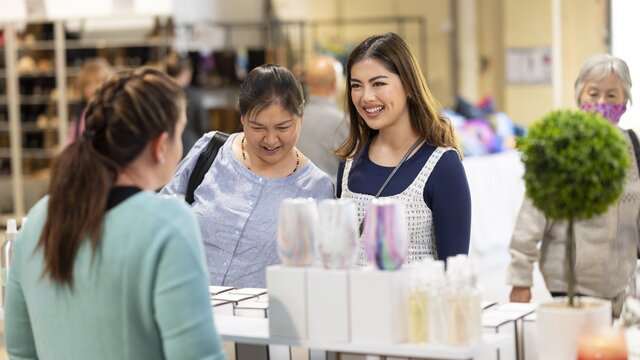 mum and daughter talking to ceramic seller