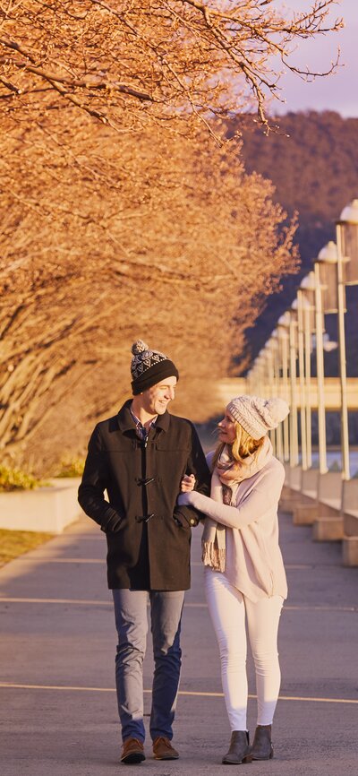 A couple walking by Lake Burley Griffin during winter