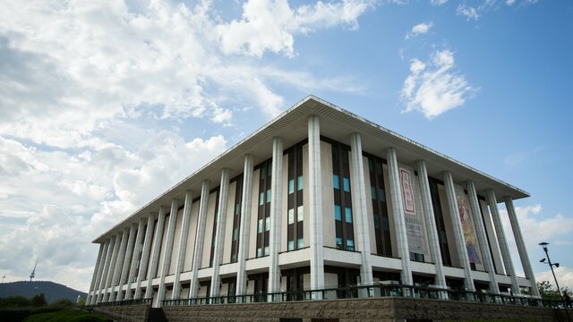 The exterior of a large white building in front of blue skies