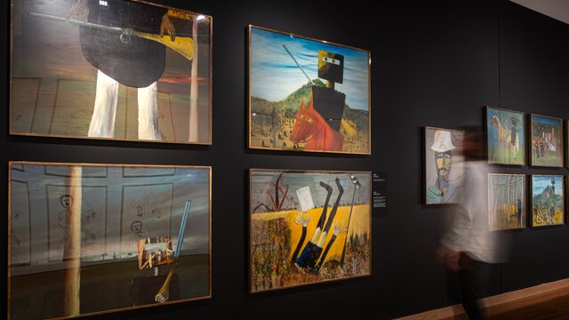 A person observing the artworks of the Nolan Collection at Canberra Museum and Gallery