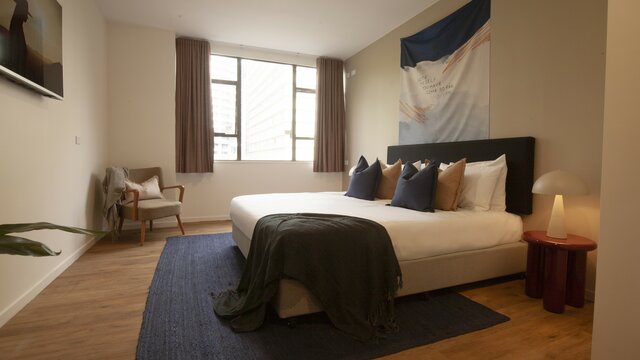 A modern and simple room with a large bed in the centre