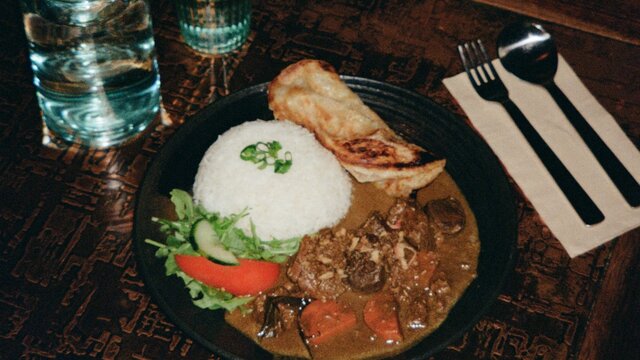 An artistic shot of a bowl of curry and rice