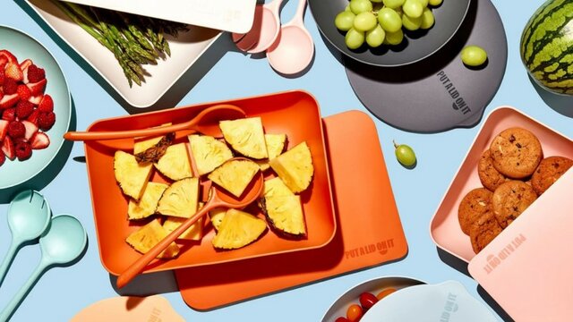 Various colourful containers and lids with food displayed in each