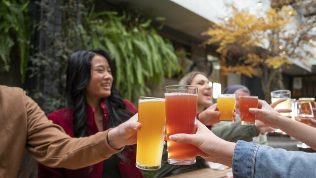 A group of friends holding beer glasses up in the air