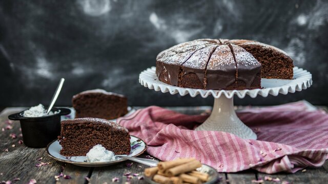 A chocolate cake on a white cake stand