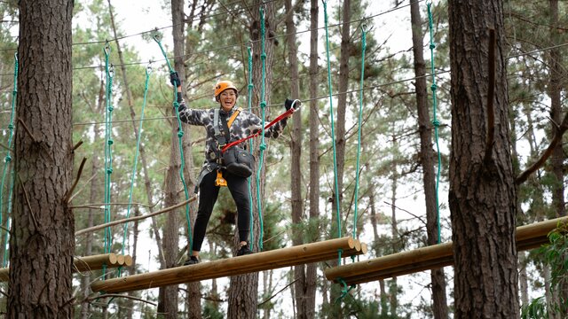 A woman completing an aerial course attached with a harness