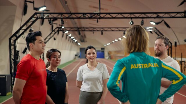 A tour group listening to an athlete