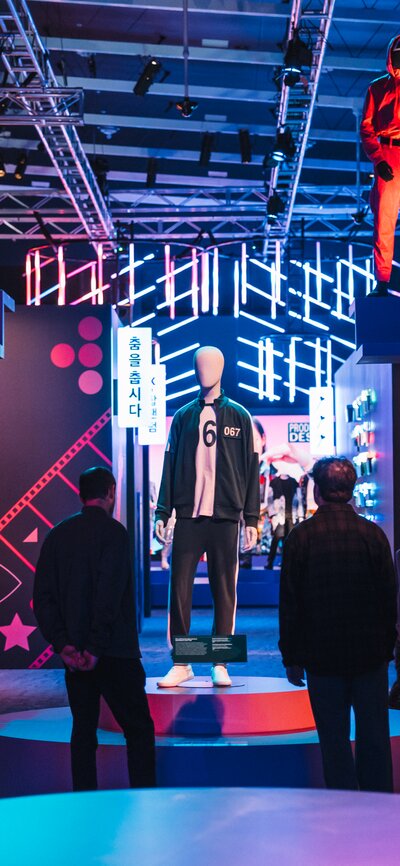 A colourful exhibition gallery space with costumes from Korean entertainment