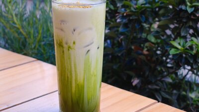 A green drink on a wooden table outdoors