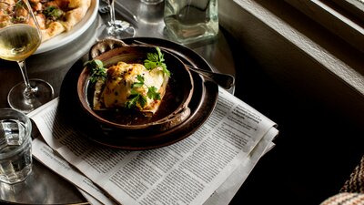 Dishes and a drink resting on a newspaper