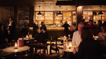 Dimly lit, cosy bar interior with seated patrons