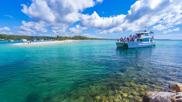Bright blue waters with a with bloat of passengers gliding over