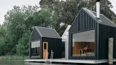 Two saunas overlooking the lake with trees in the background
