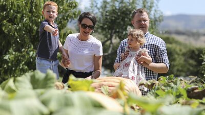 Parents and two kids look over at a garden