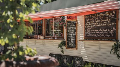 The outside of a cafe in a van with a chalkboard menu on the front