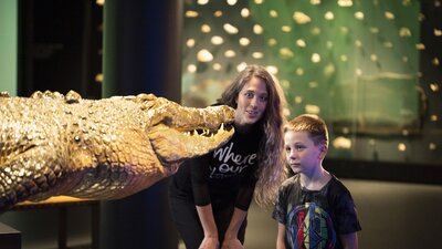 Family on free tour of National Museum of Australia looking at crocodile