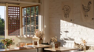 An interior of a cafe with a beige colour palette and soft light entering