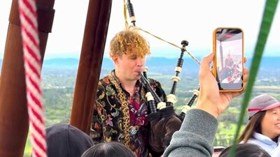 Elias Alexander plays bagpipes in hot air balloon while visiting Canberra for the National Folk Festival
