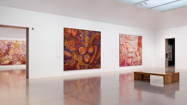 A gallery of colourful red artworks on a wall