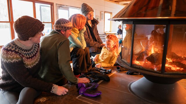 A family sits by a fireplace