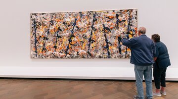 A couple stare at a well-known painting 'Blue Poles' at a gallery