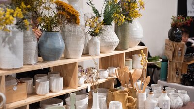 Various ceramic work displayed on wooden shelves