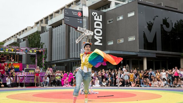 YesFest | © Cassie Plum Photography Pride performer dancing on top of the rainbow circle roundabout in Braddon, ACT with crowds watching. | © Cassie Plum Photography
