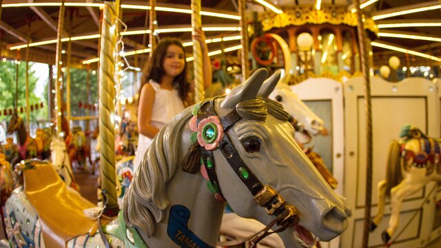 The merry-go-round illuminated in warm, yellow light.
